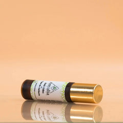 Lip balm with gold cap on a reflective surface against an orange background