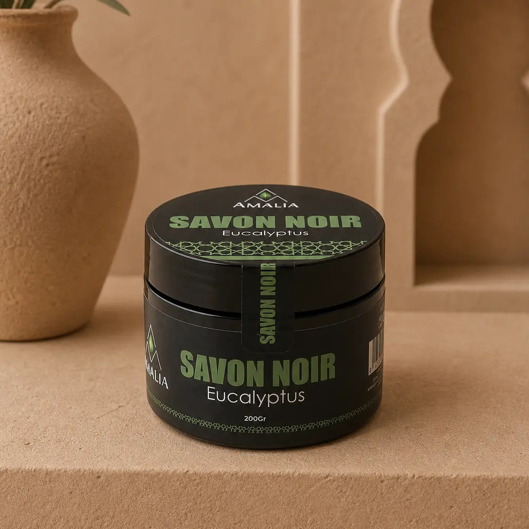 Black jar of Savon Noir Eucalyptus soap with green text on a beige background