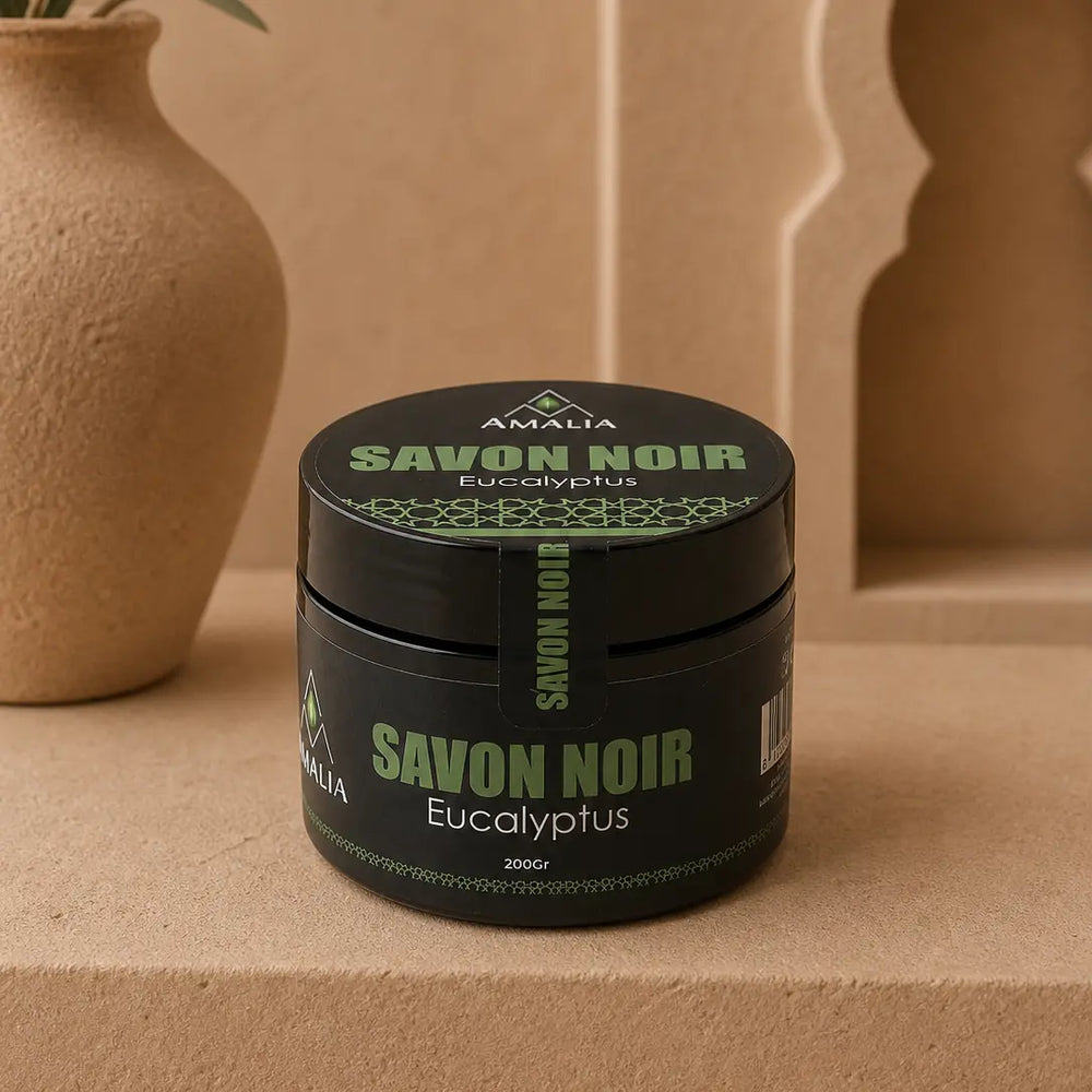 Black jar of Savon Noir Eucalyptus soap with green text on a beige background