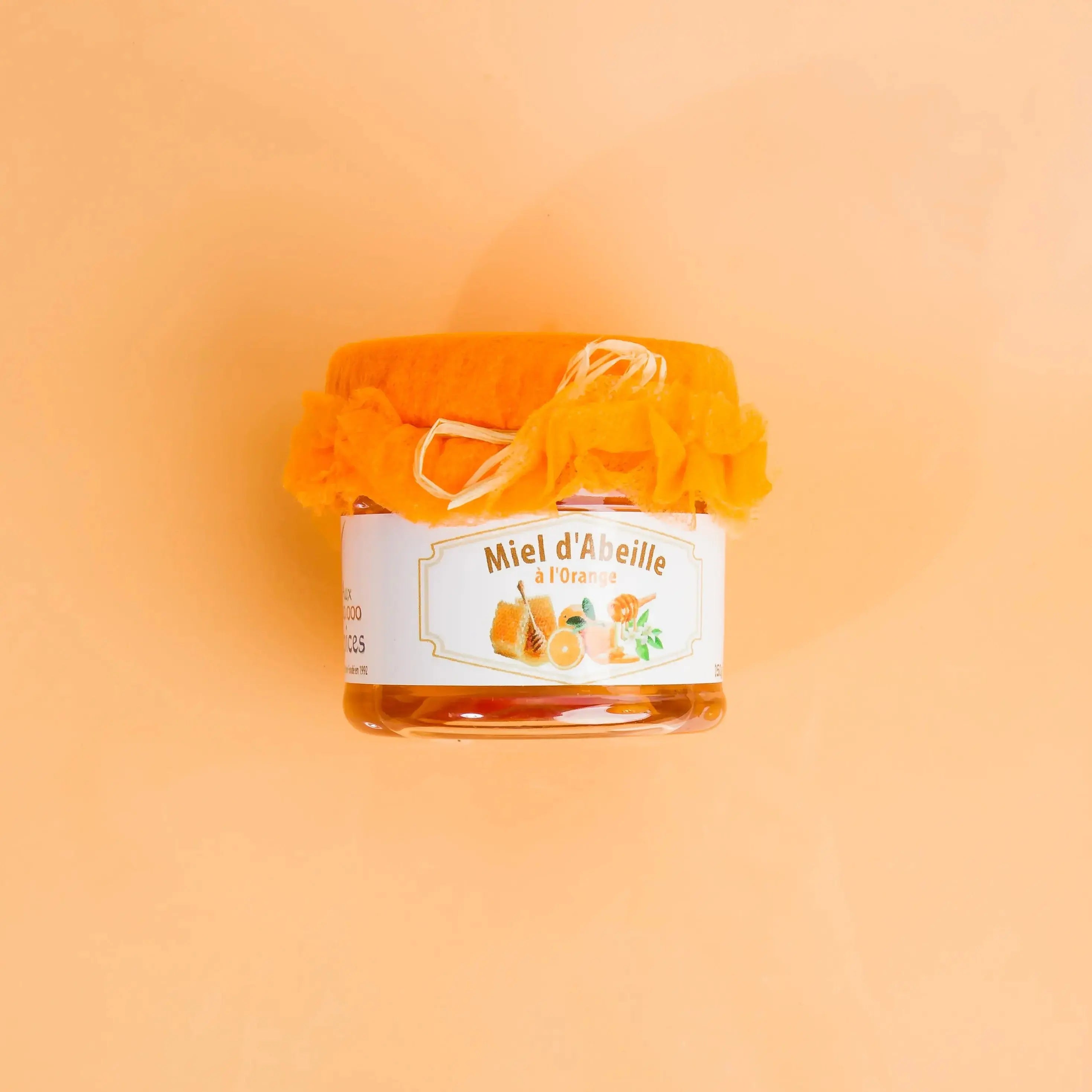 Jar of honey with a label on an orange background