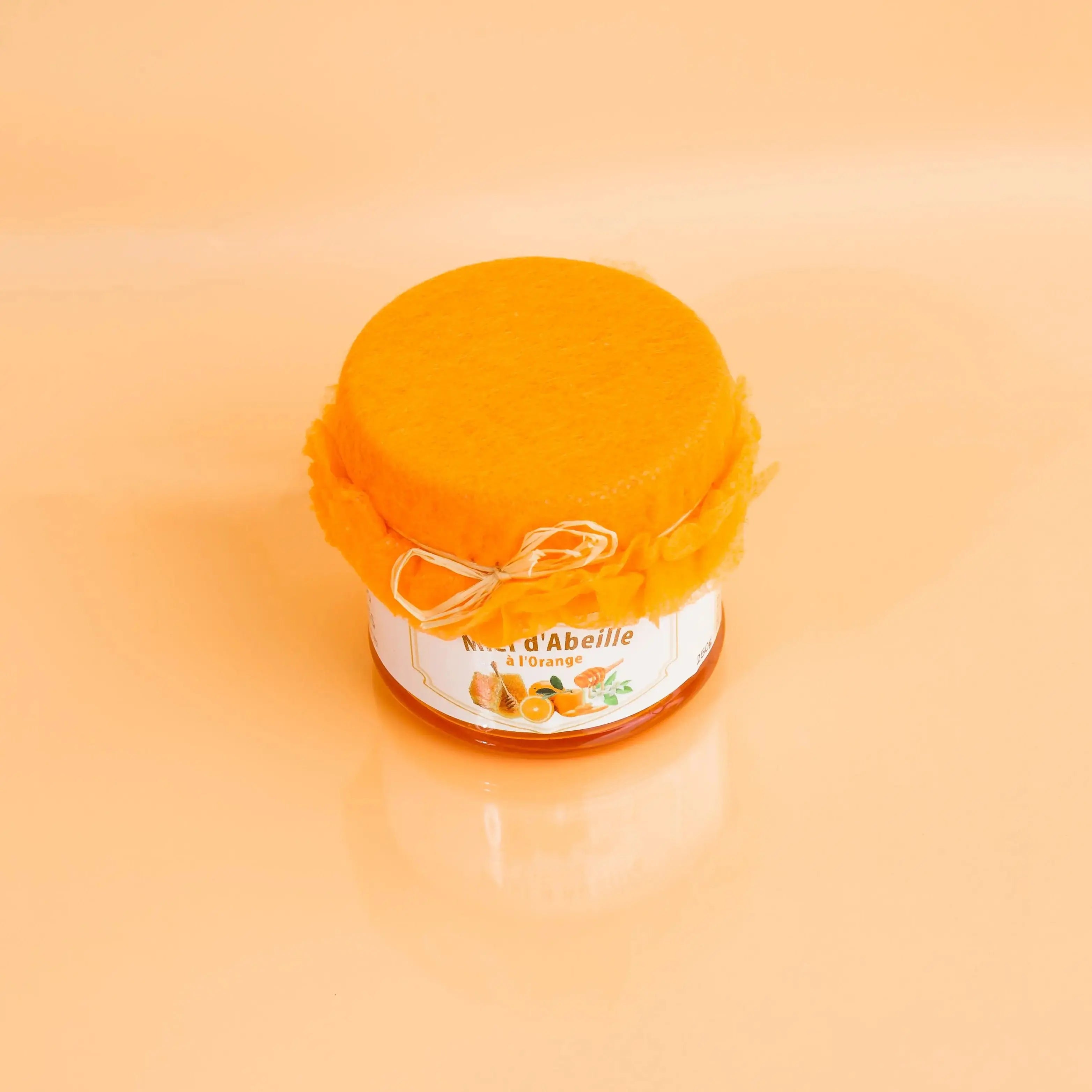 Jar of honey with a label on an orange background