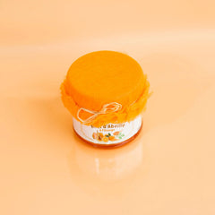 Jar of honey with a label on an orange background